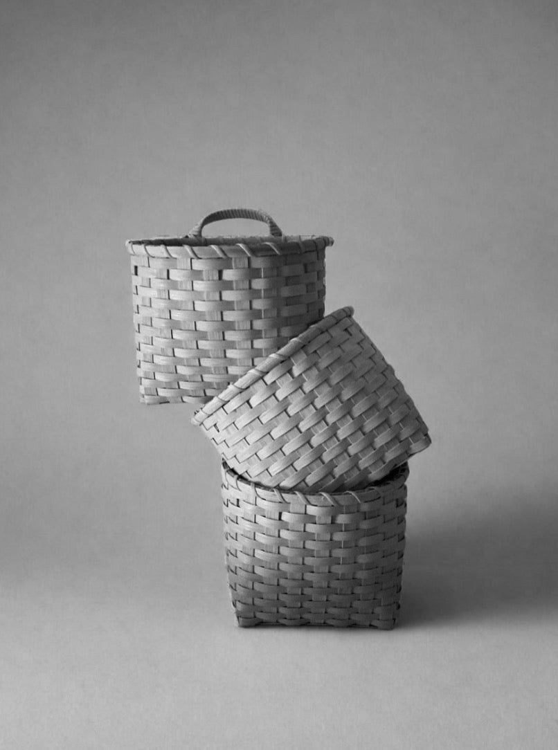 Underwater Weaving Studio trail basket made of natural woven materials with sturdy handles for outdoor use.