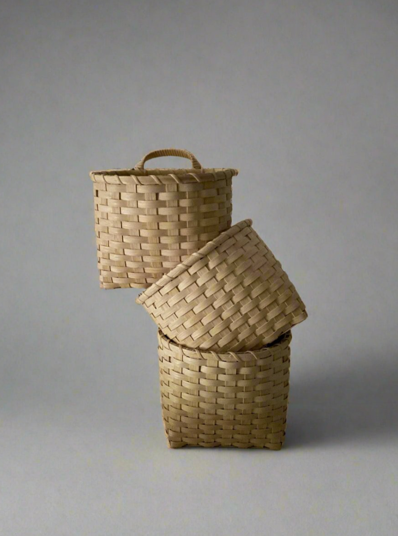 Underwater Weaving Studio Trail Basket made of natural woven materials, showcasing its sturdy handle and rustic design.
