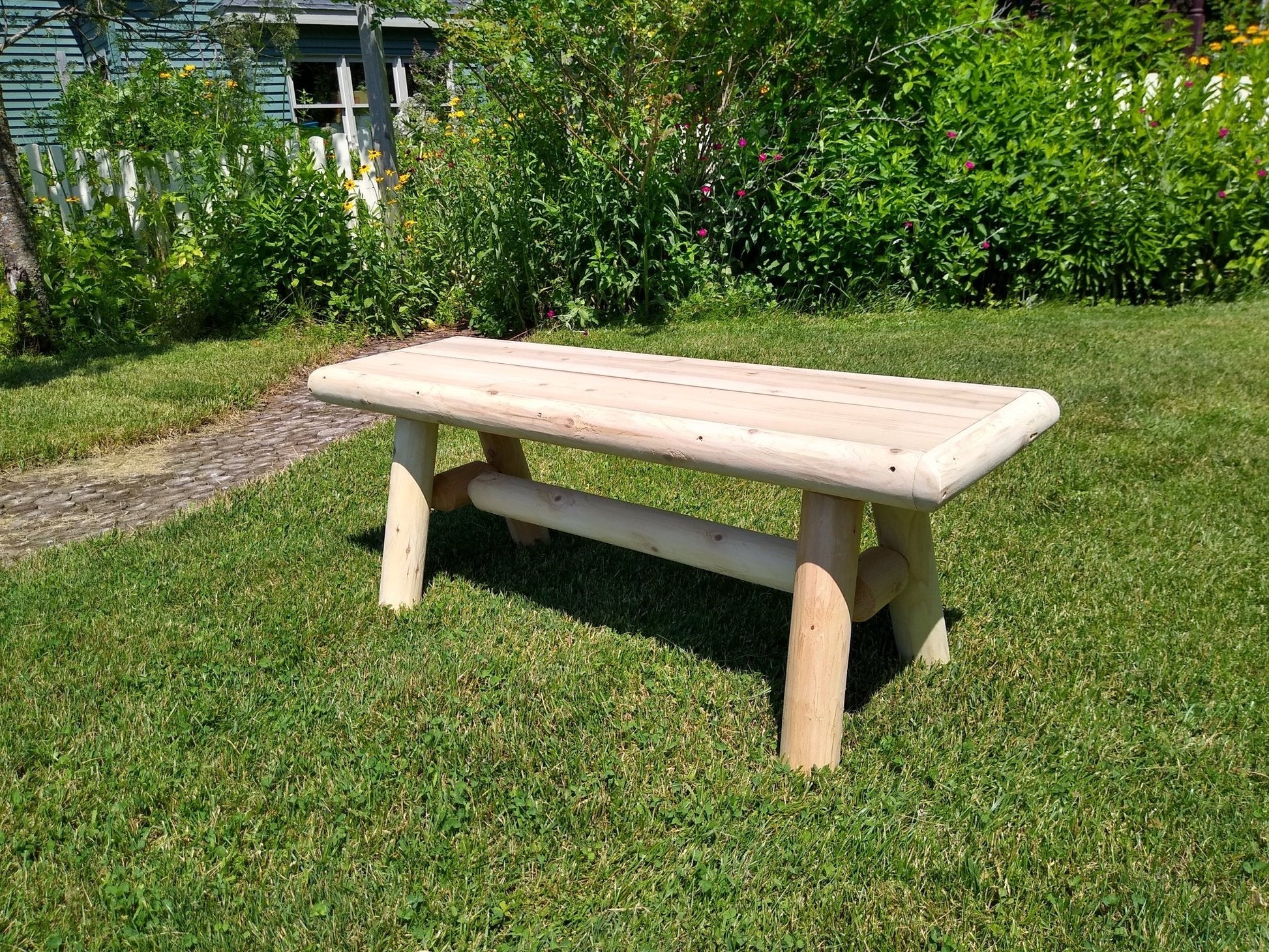 Rustic outdoor farmhouse entryway bench by Cedar Creek Rustic Furniture, sturdy wooden seating for garden or porch decor.