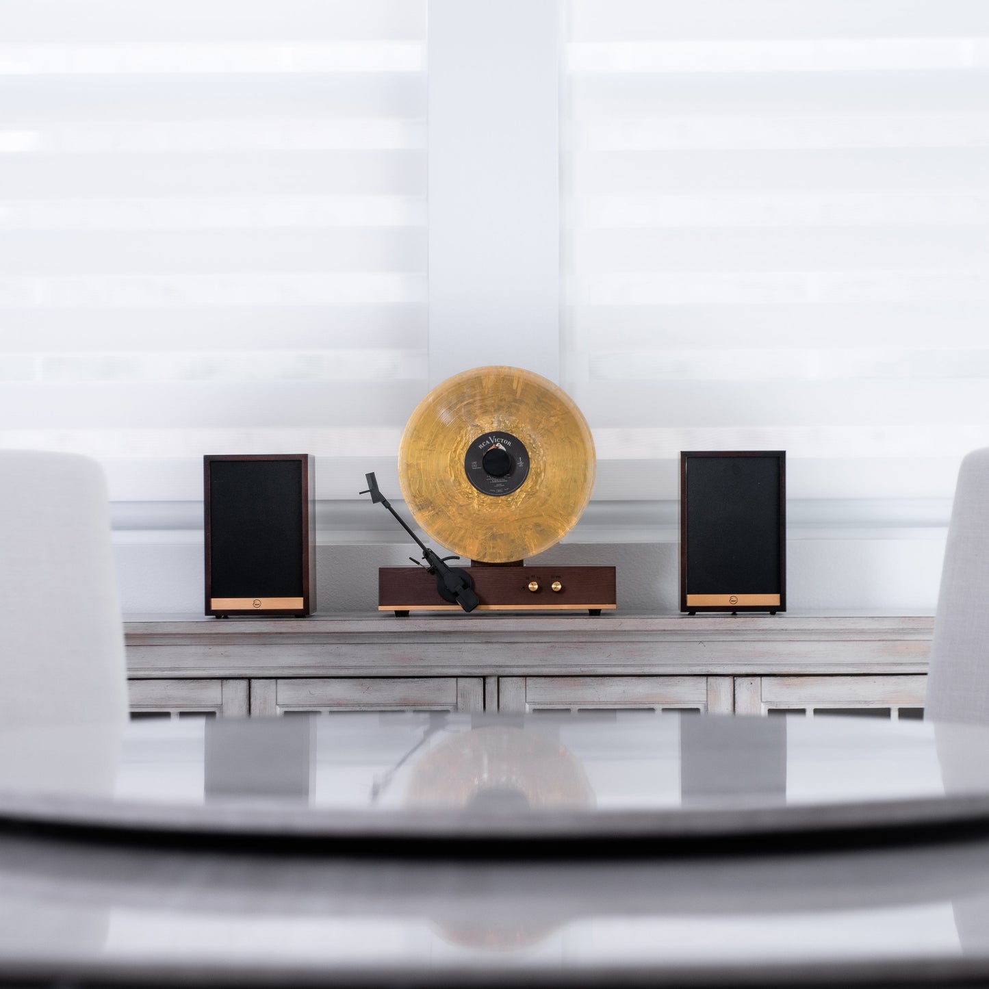 Fuse Audio GLD vertical vinyl record player on a display stand, showcasing its sleek design and turntable features.