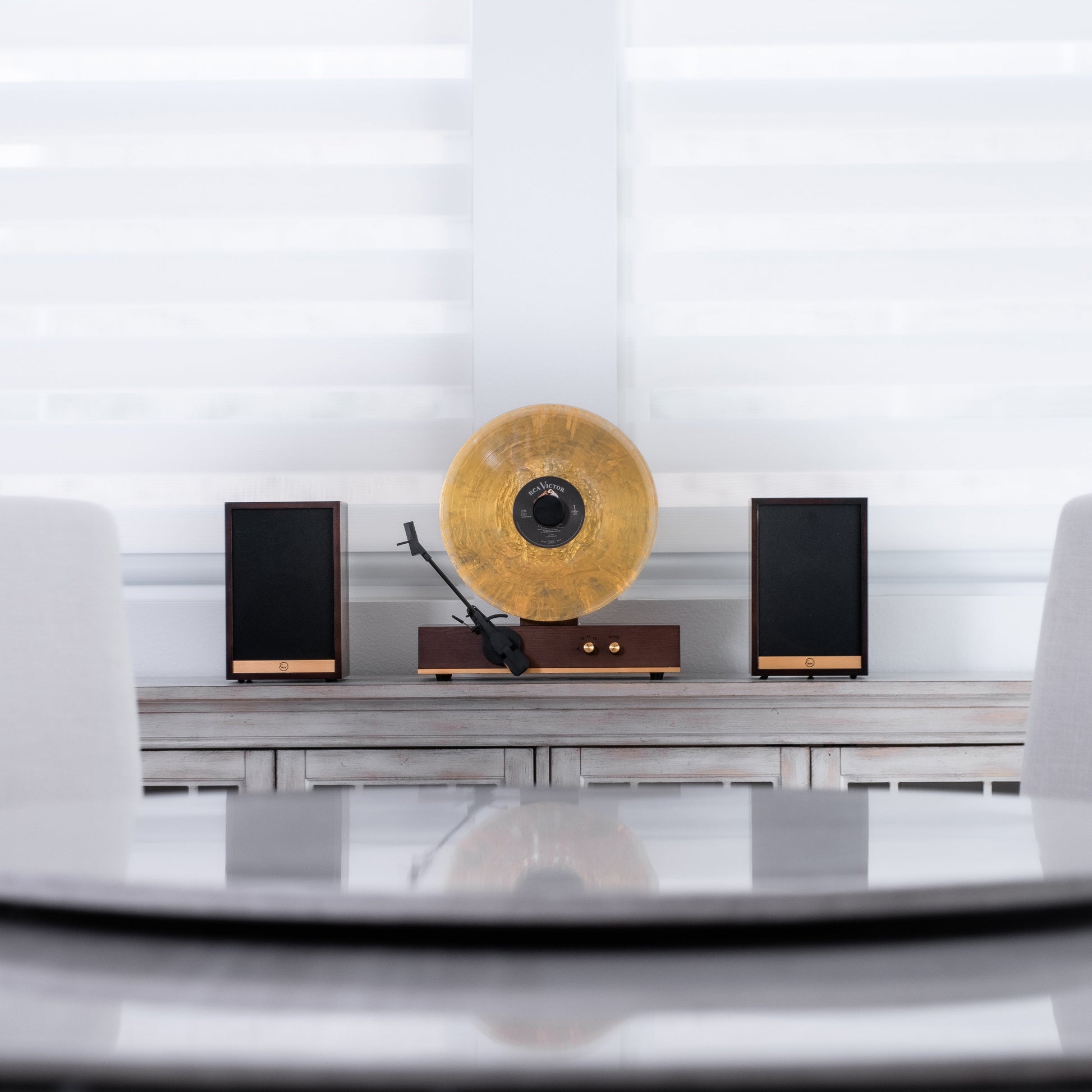 Fuse Audio GLD vertical vinyl record player on a display stand, showcasing its sleek design and turntable features.