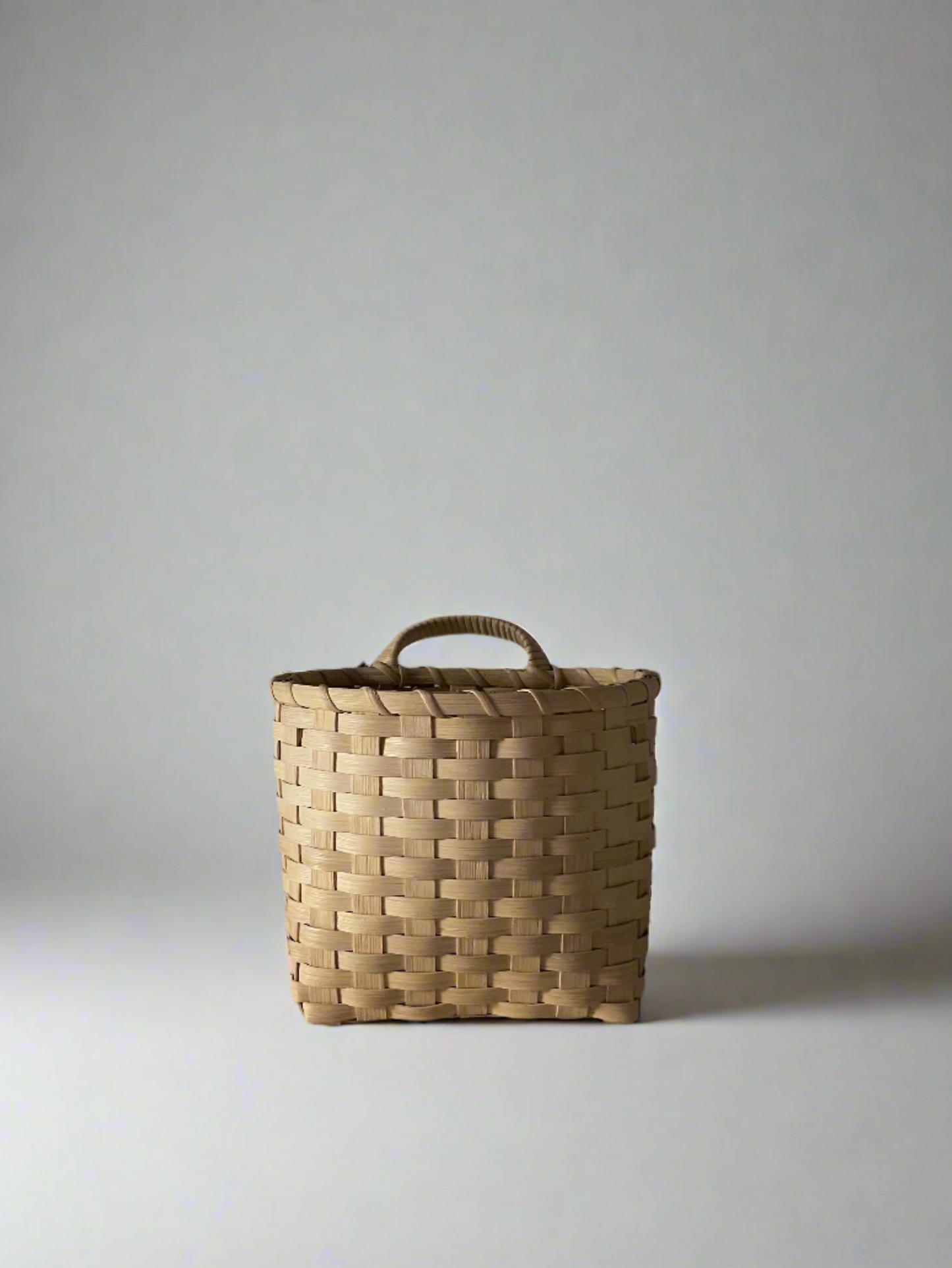 Handwoven UNDERWATER WEAVING STUDIO Trail Basket made of natural fibers, showcasing its sturdy, rustic design and craftsmanship.