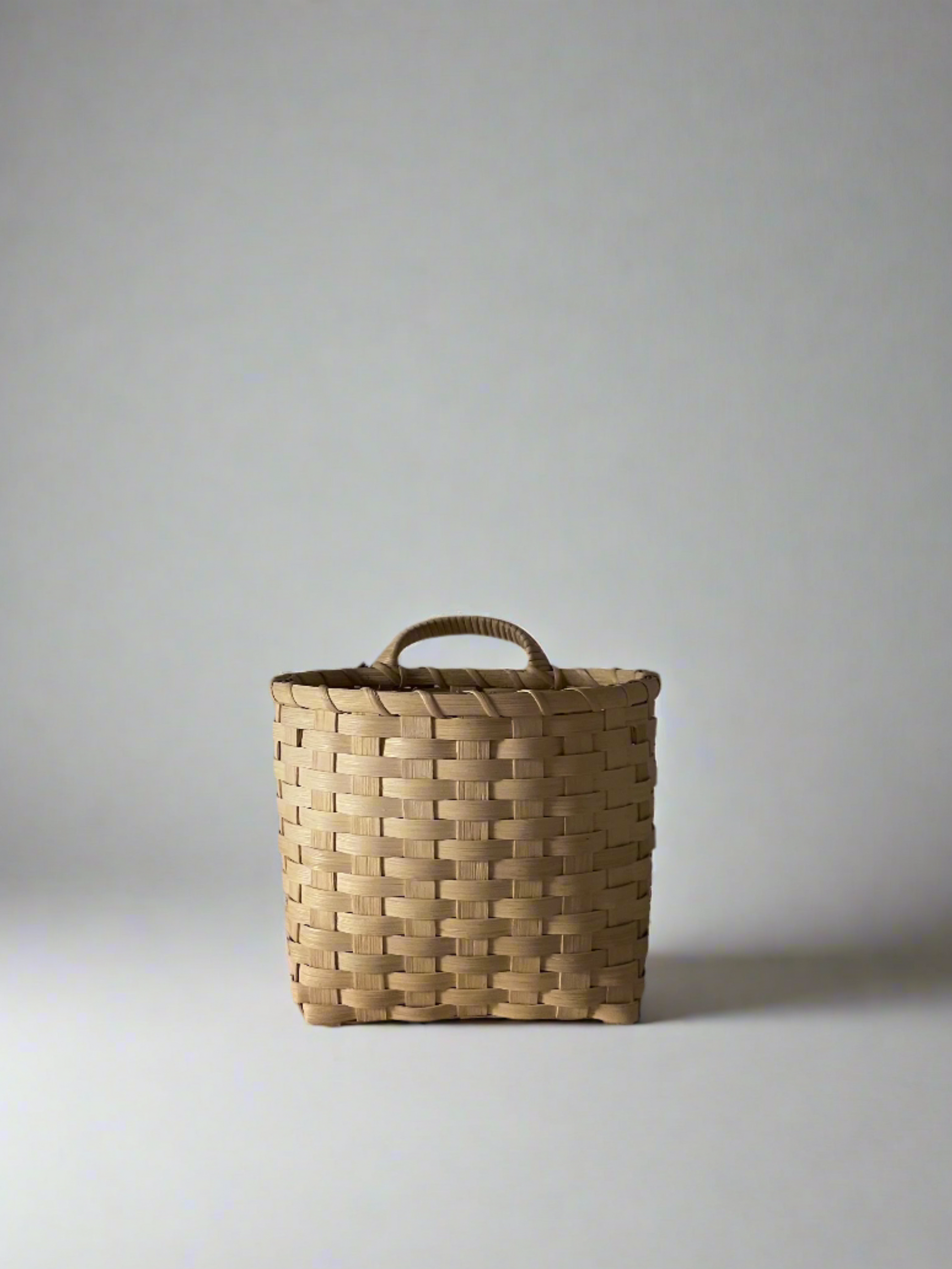 Handwoven UNDERWATER WEAVING STUDIO Trail Basket made of natural fibers, showcasing its sturdy, rustic design and craftsmanship.