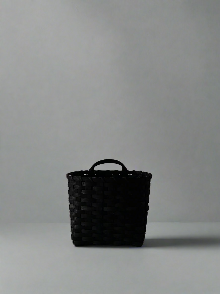 Black Trail Basket by UNDERWATER WEAVING STUDIO, woven basket with sturdy handle, ideal for outdoor storage or decor.