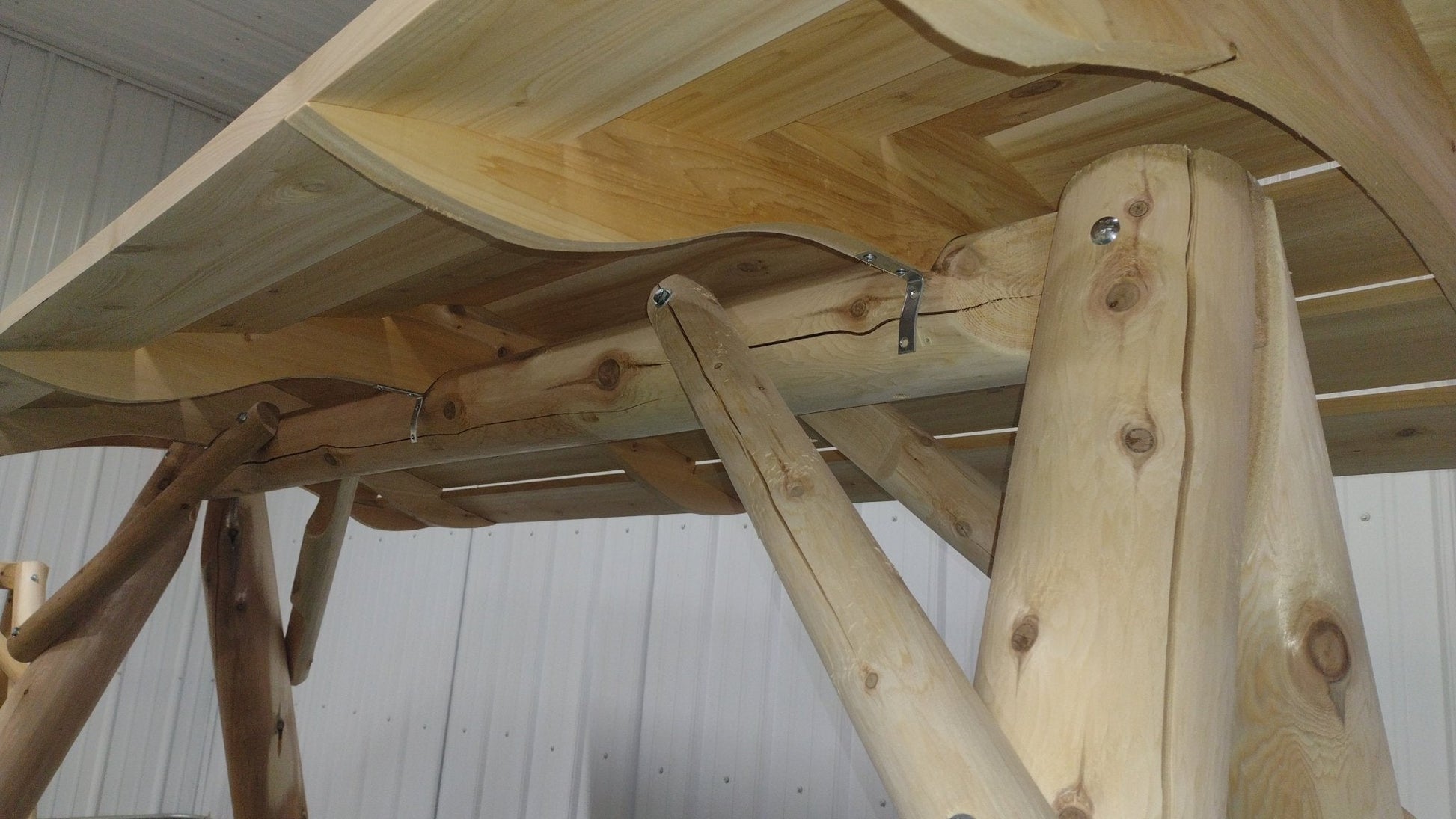 Wooden porch swing with canopy, made by Cedar Creek Rustic Furniture, featuring a sturdy frame and comfortable seating.