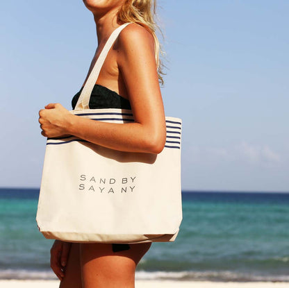Sand By Saya New York Stripe Beach Tote with woven handles and spacious interior for carrying beach essentials.